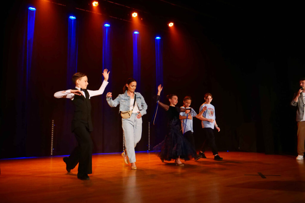 Tancerze, konferansjer i uczestnicy imprezy na scenie podczas dnia dziecka 4 czerwca 2022 w Miejskim Ośrodku Kultury w Wojkowicach