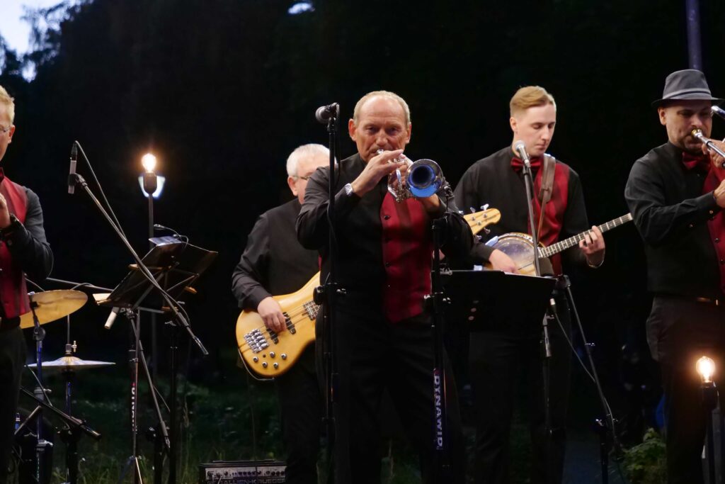 Muzycy na scenie podczas wieczorku muzycznego z Five O'Clock Orchestra w Parku Miejskim w Wojkowicach 2 lipca 2022