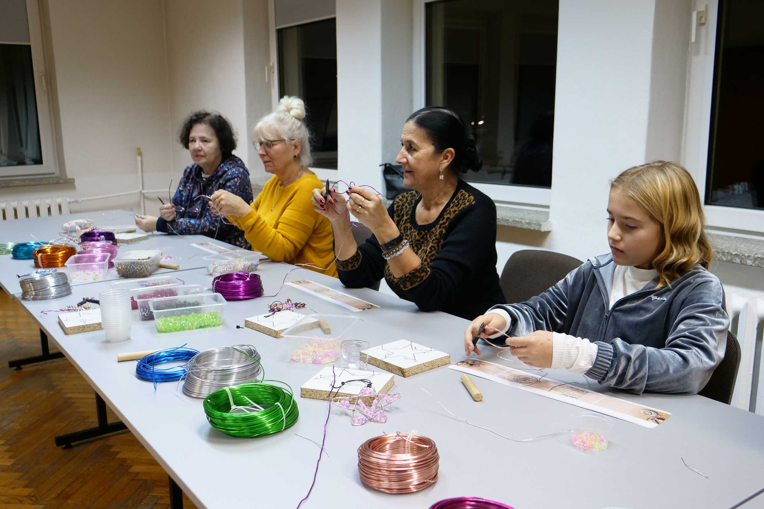 Uczestnicy tworzący ozdoby świąteczne podczas warsztatów twórczych w MOK Wojkowice 15 grudnia 2022