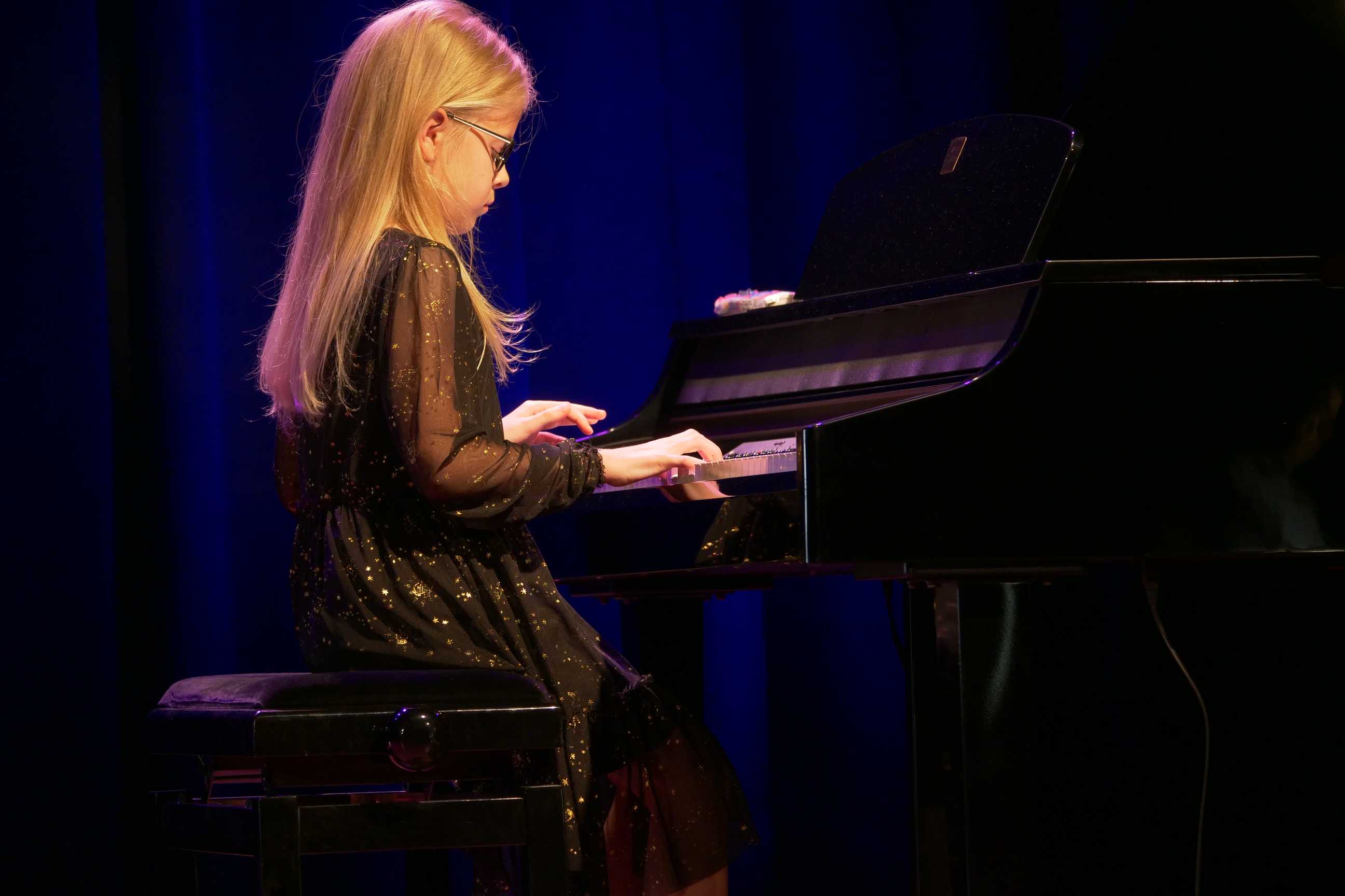 Pianistka na scenie podczas popisów muzyczne dzieci i młodzieży w Miejskim Ośrodku Kultury w Wojkowicach