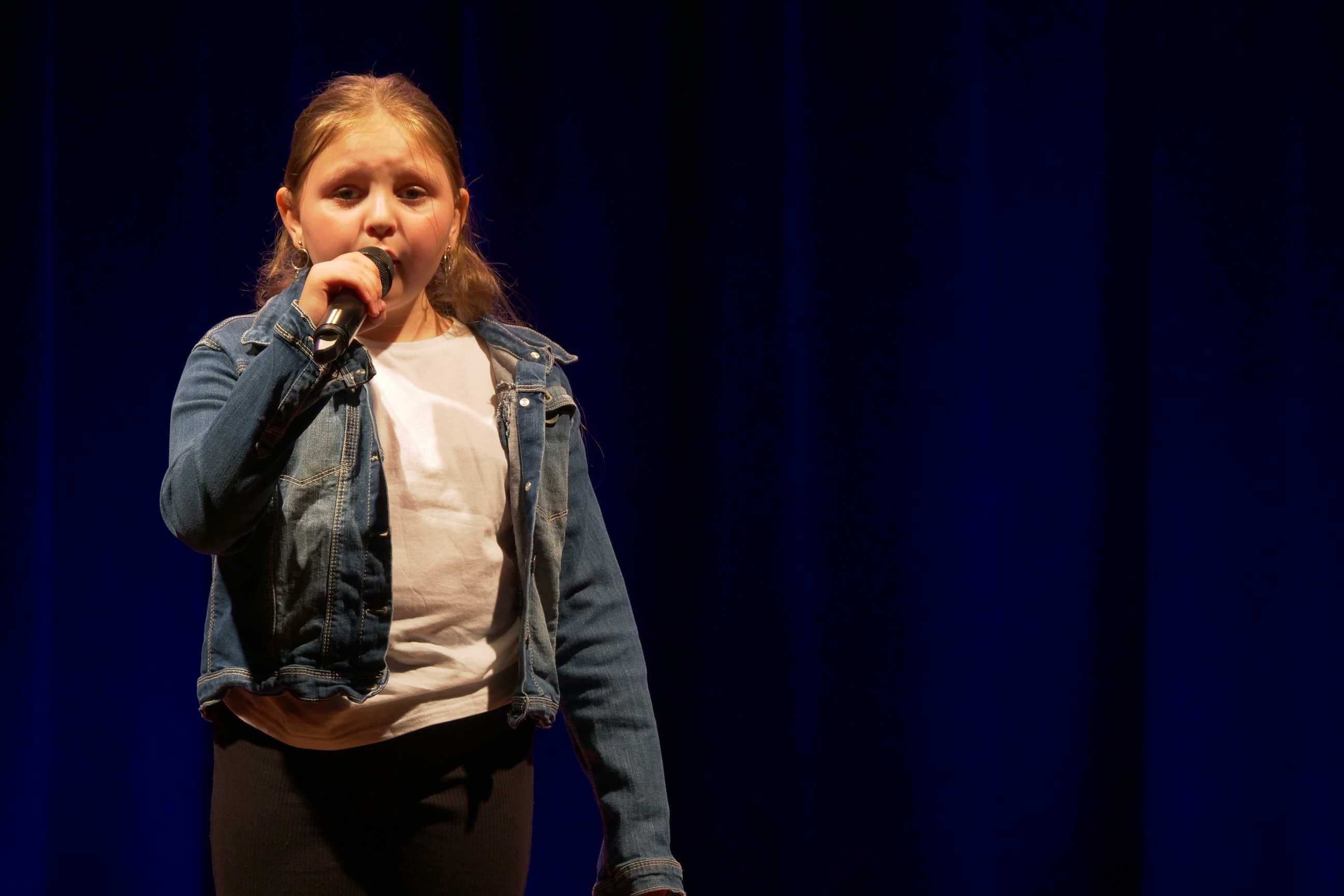Wokalistka na scenie podczas popisów muzyczne dzieci i młodzieży w Miejskim Ośrodku Kultury w Wojkowicach