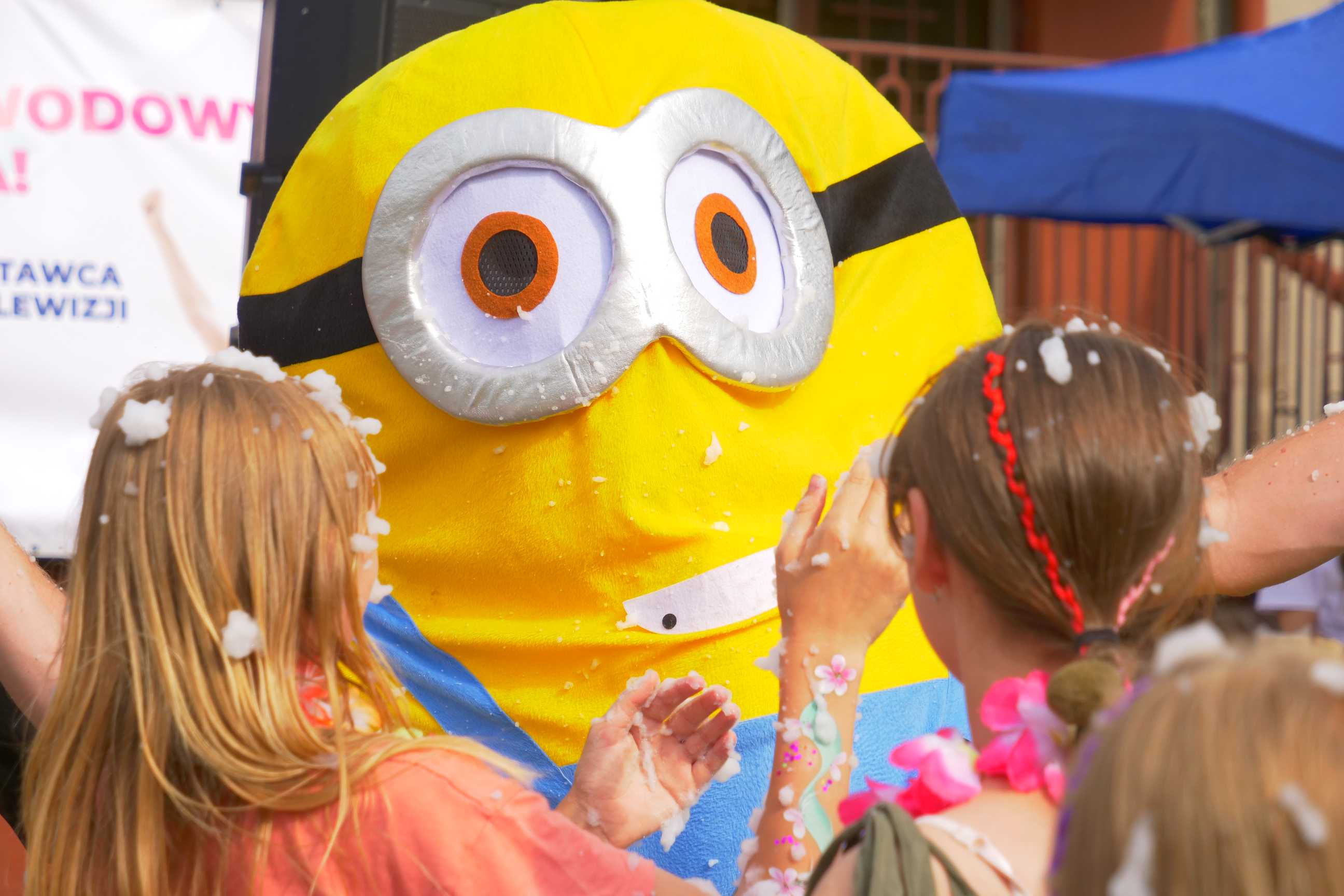 Uczestnicy imprezy i maskotka minionka podczas imprezy Witamy Wakacje przy budynku Miejskiego Ośrodka Kultury w Wojkowicach 23 czerwca 2023